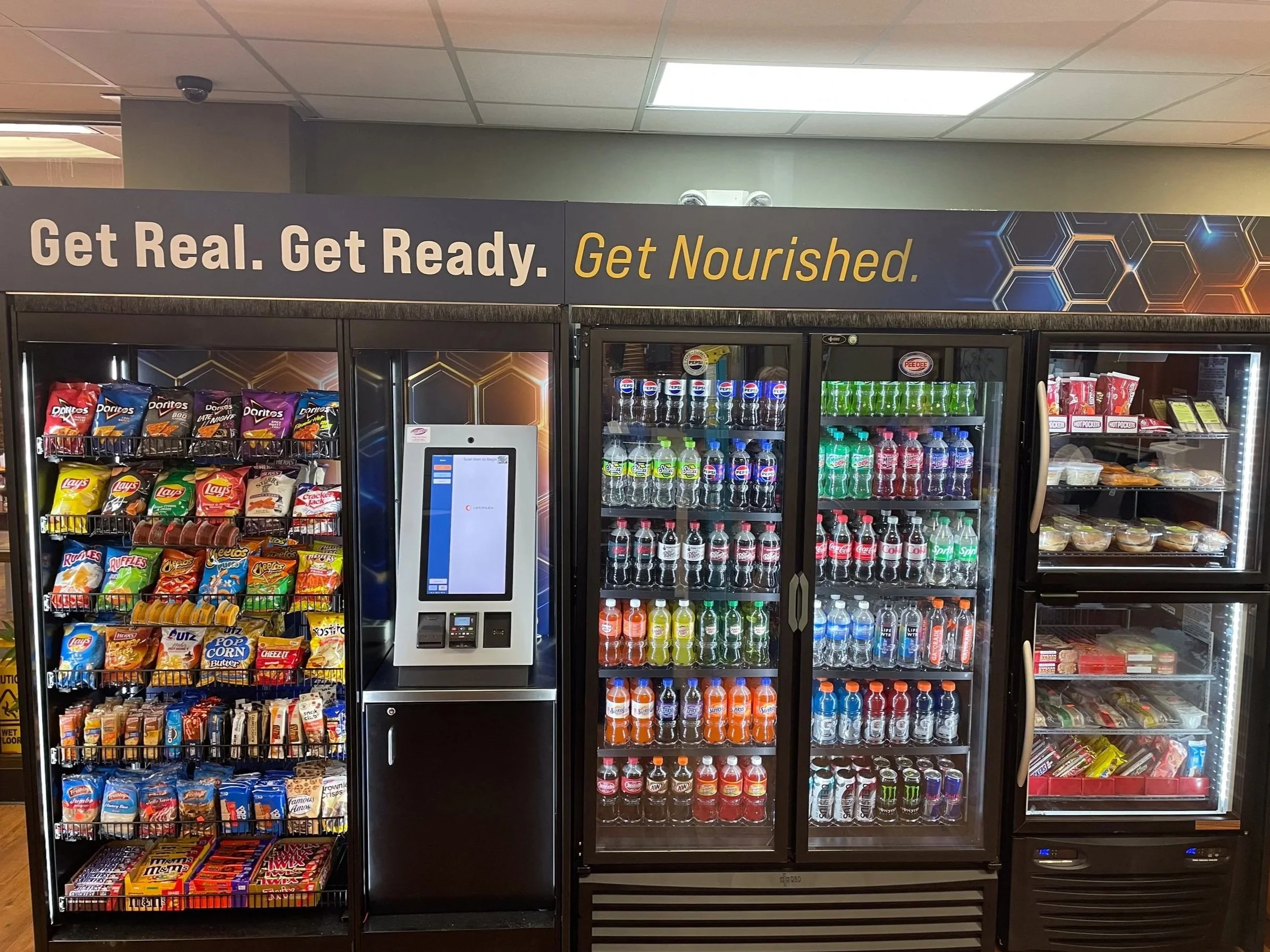 Vending machines with snacks, beverages, and packaged food at a convenience store.