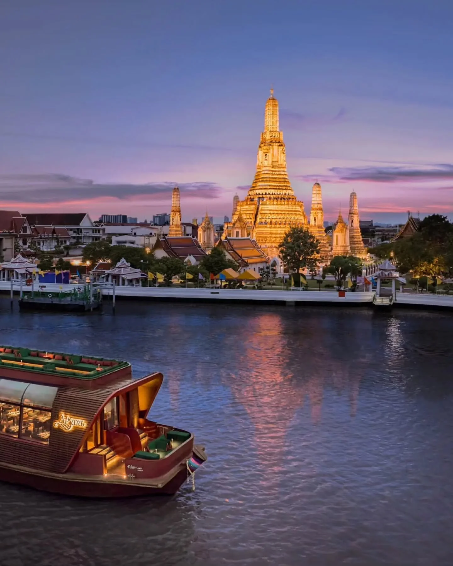 Riverside enchantment in Bangkok &mdash; Wat Arun radiates celestial beauty at twilight as an opulent dinner cruise glides gracefully past.