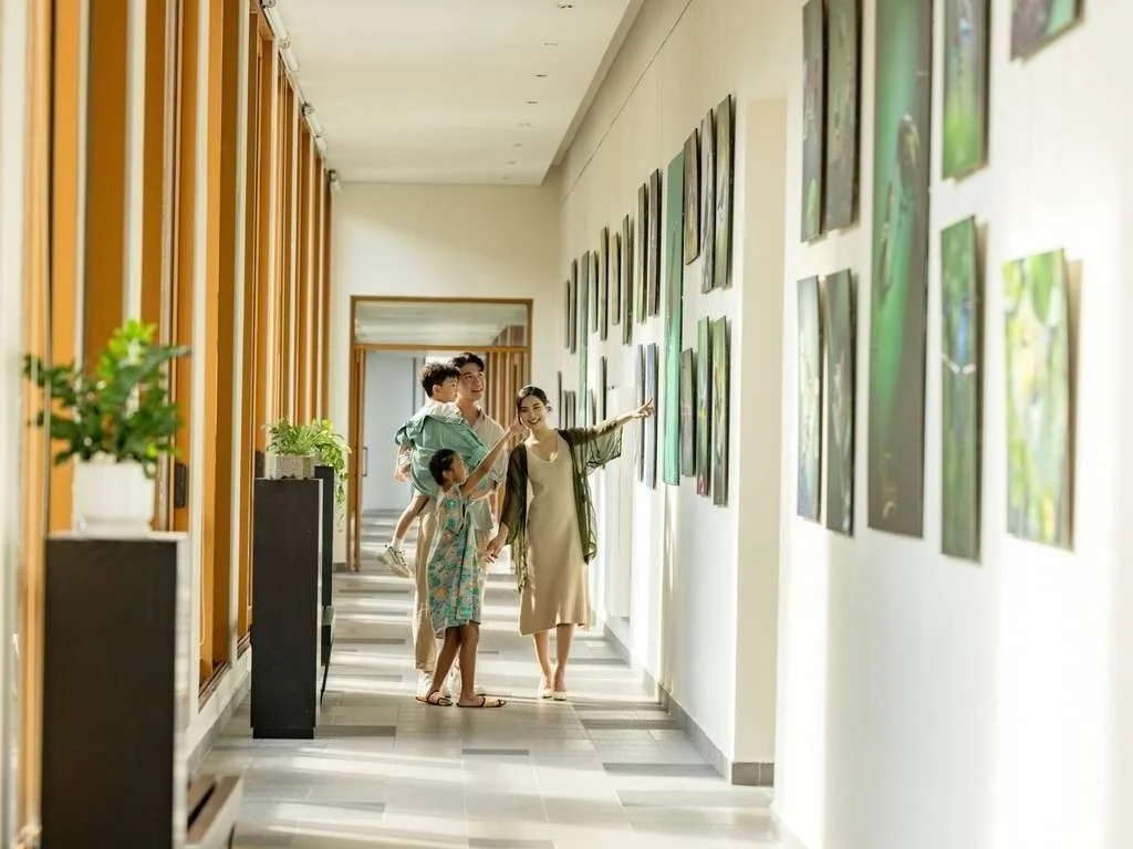 Family viewing artwork in a well-lit gallery hallway.