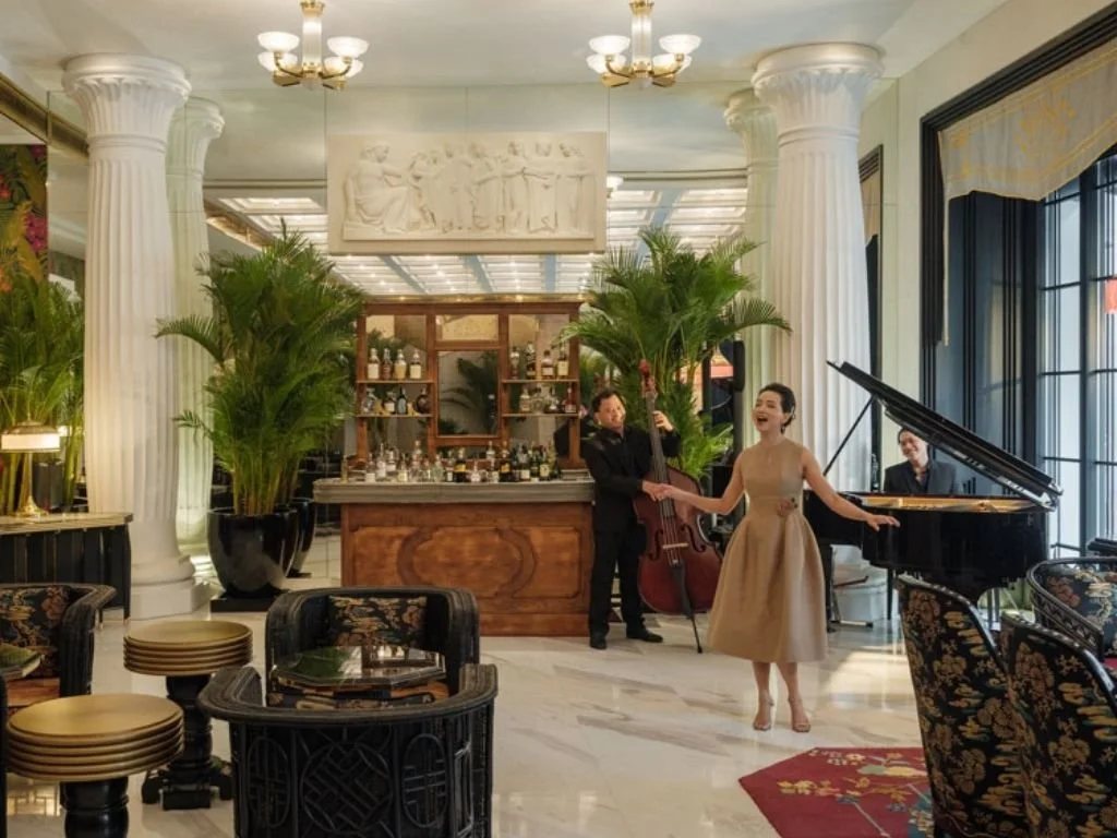 Live opera musical performance featuring a vocalist, grand piano, and double bass in the salon at Capella Hanoi, Vietnam.