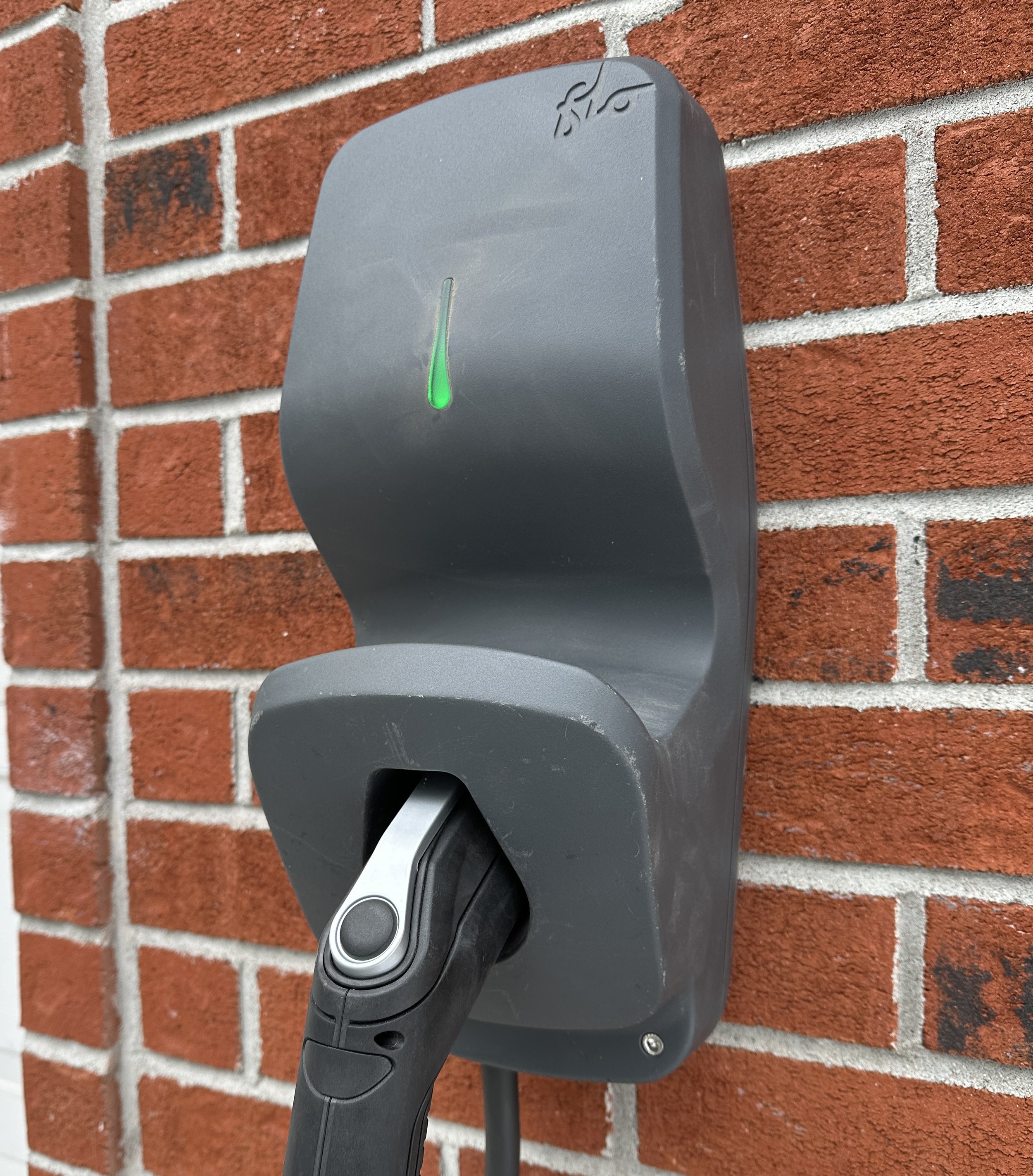 Un chargeur électrique de type station de chargement portable de couleur noire, marqué 'GRIZZL8E' avec un câble électrique attaché.