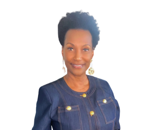 Portrait of an African American woman with short curly hair, wearing a denim jacket with gold buttons and a yellow top underneath, smiling at the camera.