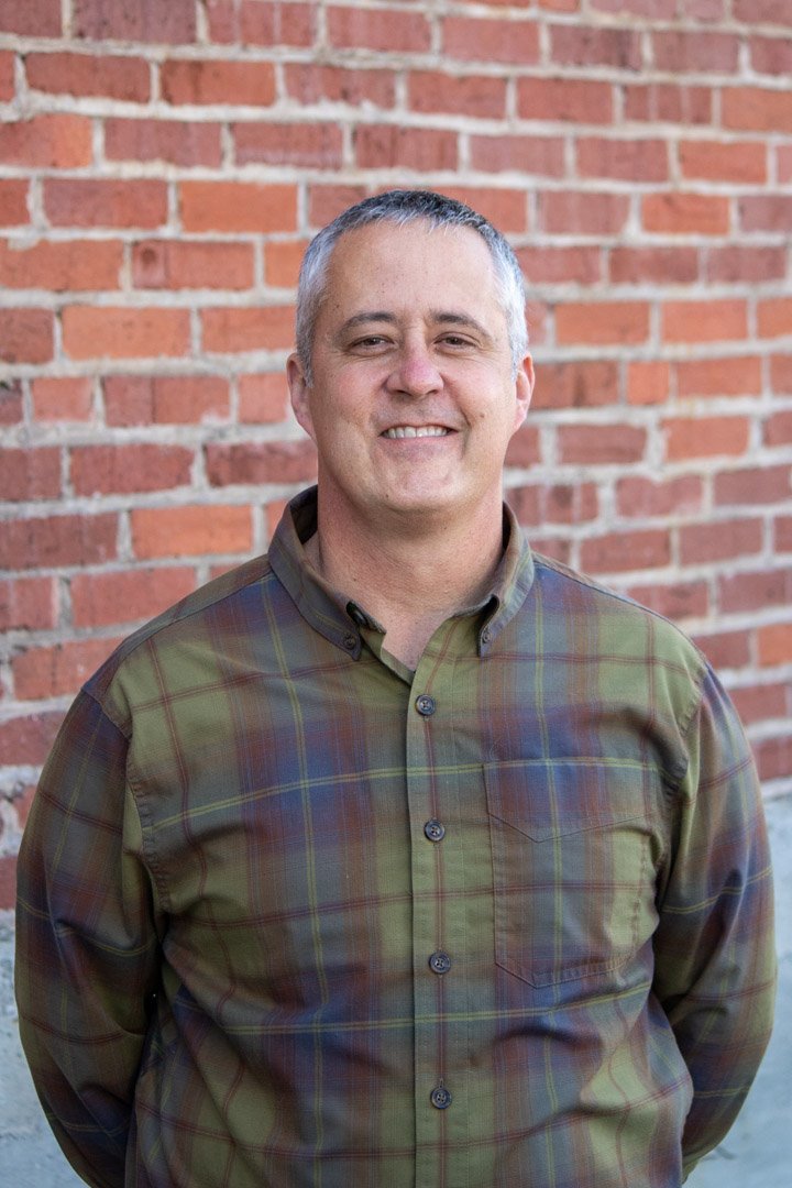 Eric Beck portrait in front of brick wall.
