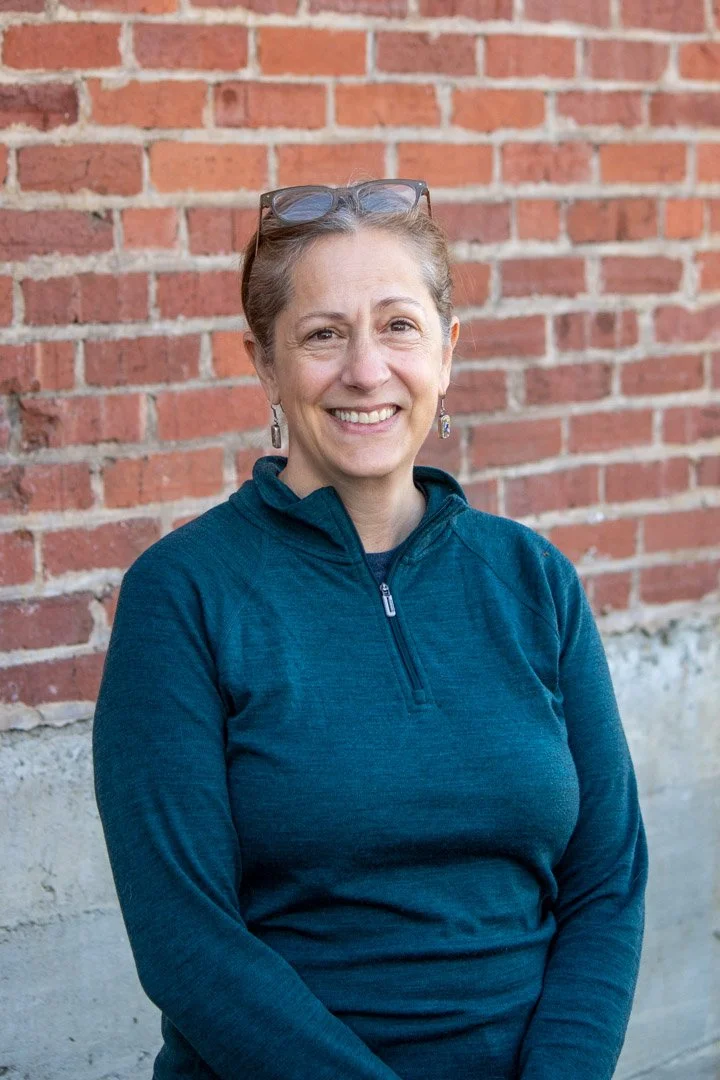 Susan Landes Beck portrait in front of brick wall.