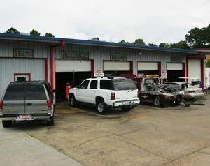Cars parked outside a service garage building with open bays