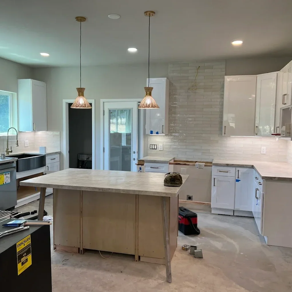 Partially completed kitchen remodel with new lighting and cabinetry, illustrating a home renovation project where outdated knob-and-tube wiring may be uncovered and assessed for safety upgrades.