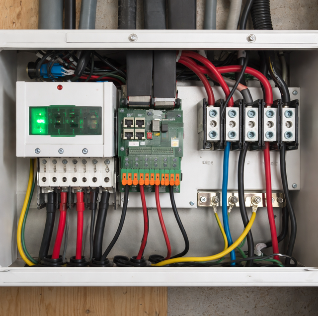 electrician installing whole-house surge protector in electrical panel