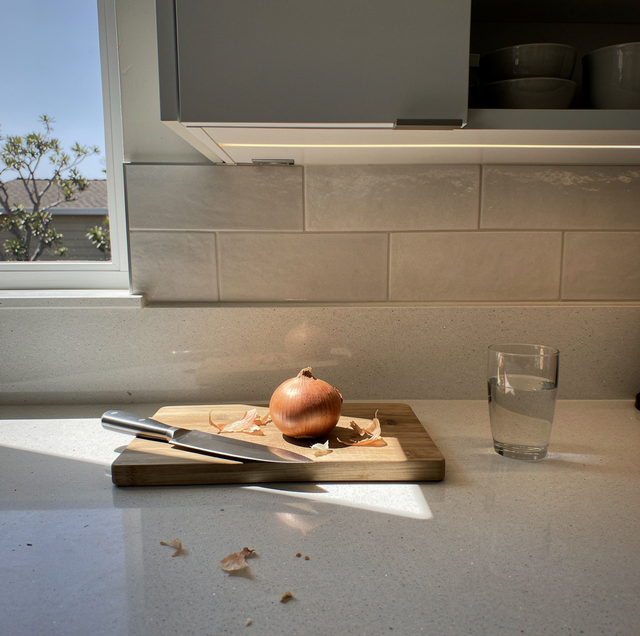Modern kitchen with lit under cabinet lights above quartz counter