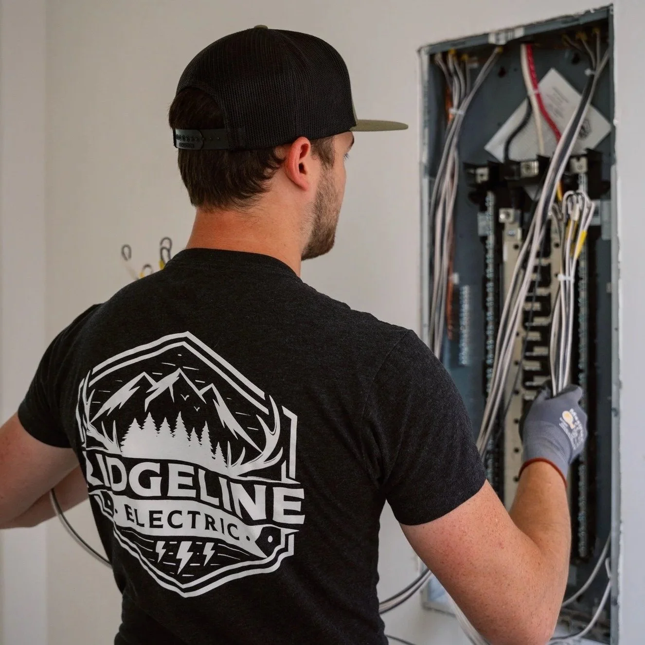 Electrician wiring an electrical panel for a Level 2 EV charger installation, demonstrating residential electrical upgrades, dedicated circuit setup, and service capacity improvements for electric vehicle charging.