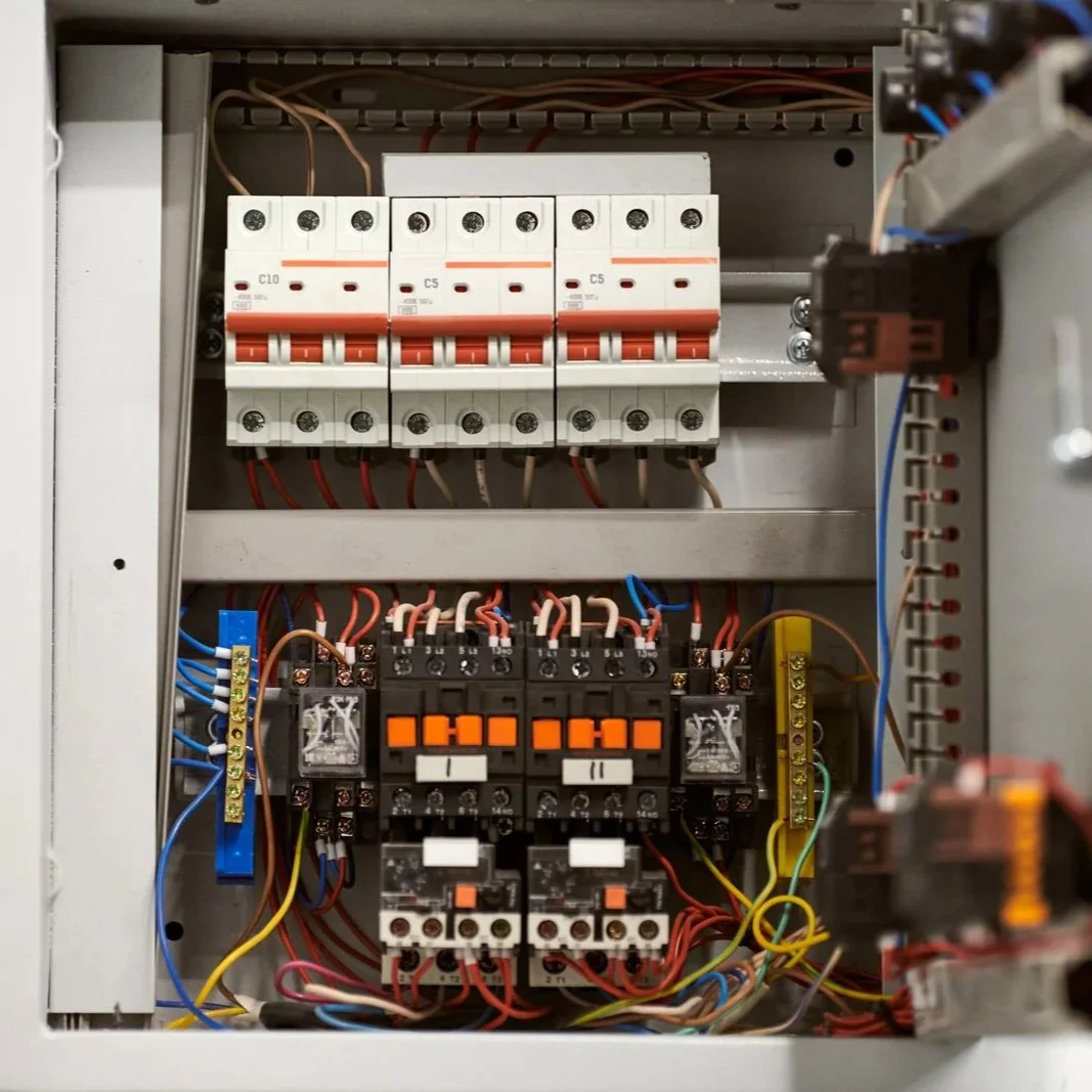 Open electrical panel displaying circuit breakers, relays, and organized wiring, illustrating a residential or commercial electrical service upgrade, panel replacement, or system inspection by an electrician.