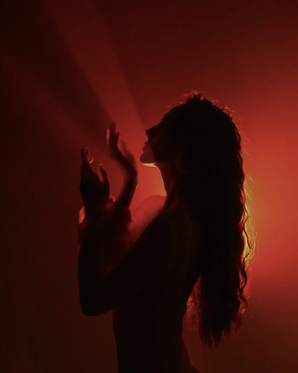 Colorful sunset over a body of water with a blurry reflection and streaked clouds.