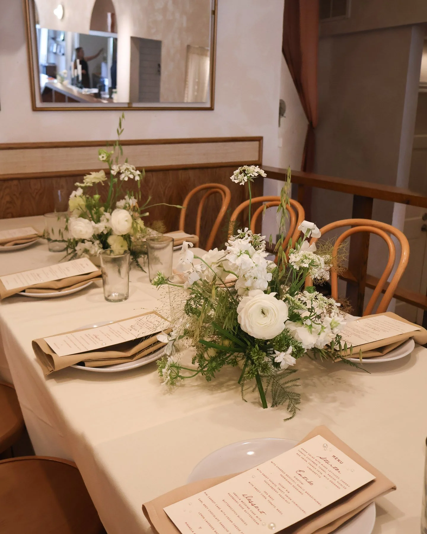 Elegant wedding reception setup with floral centerpieces in a moody green dining room