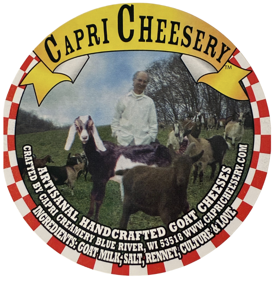 Circular label for Capri Cheesery featuring a man with goats and other animals outdoors, and text describing handmade goat cheeses from Blue River, Wisconsin.