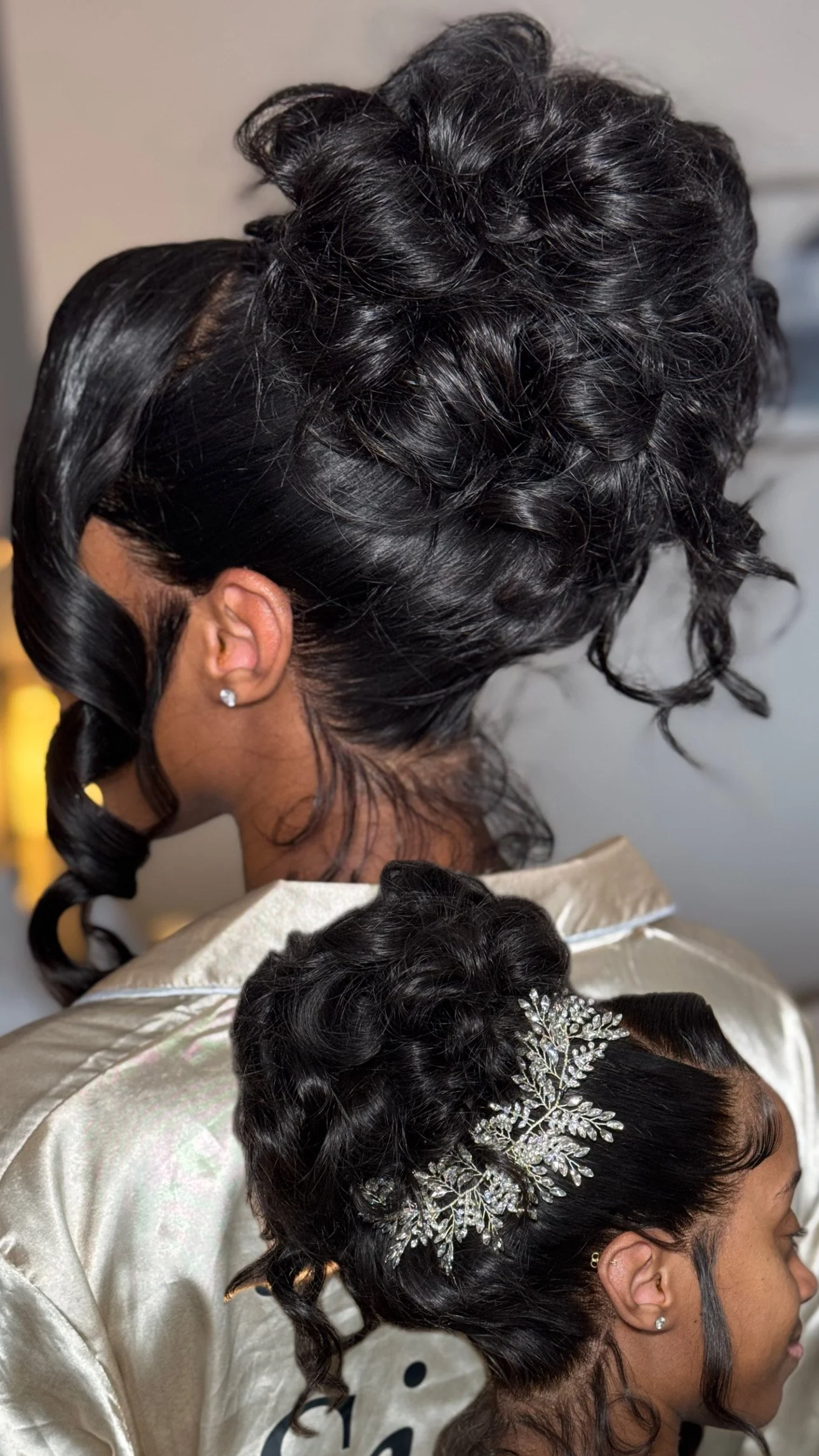 Close-up view of two women with styled black hair, one with an elegant hair accessory, and intricate hair curls, seen from the side.