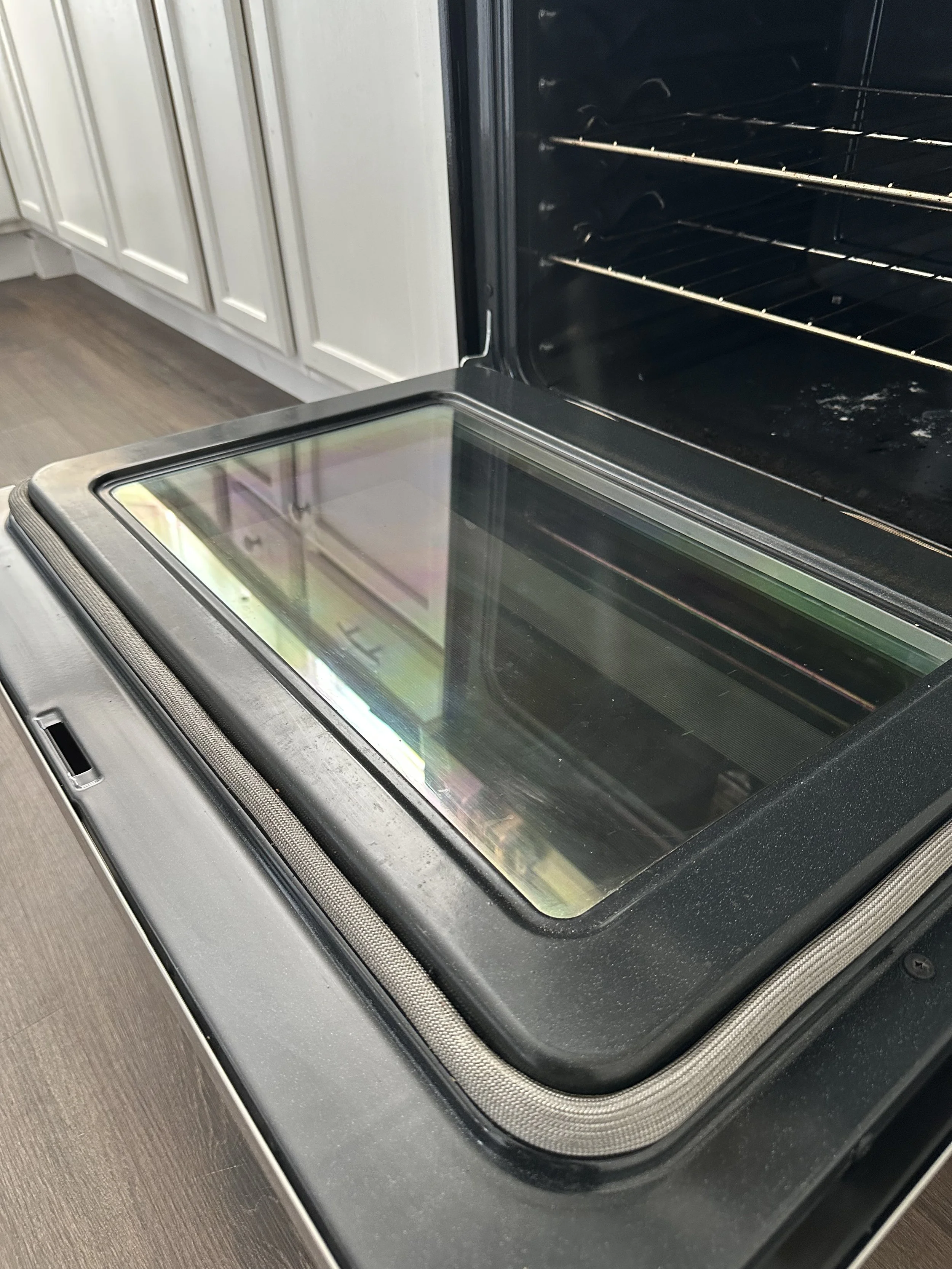 Empty black oven with glass door in a modern kitchen.