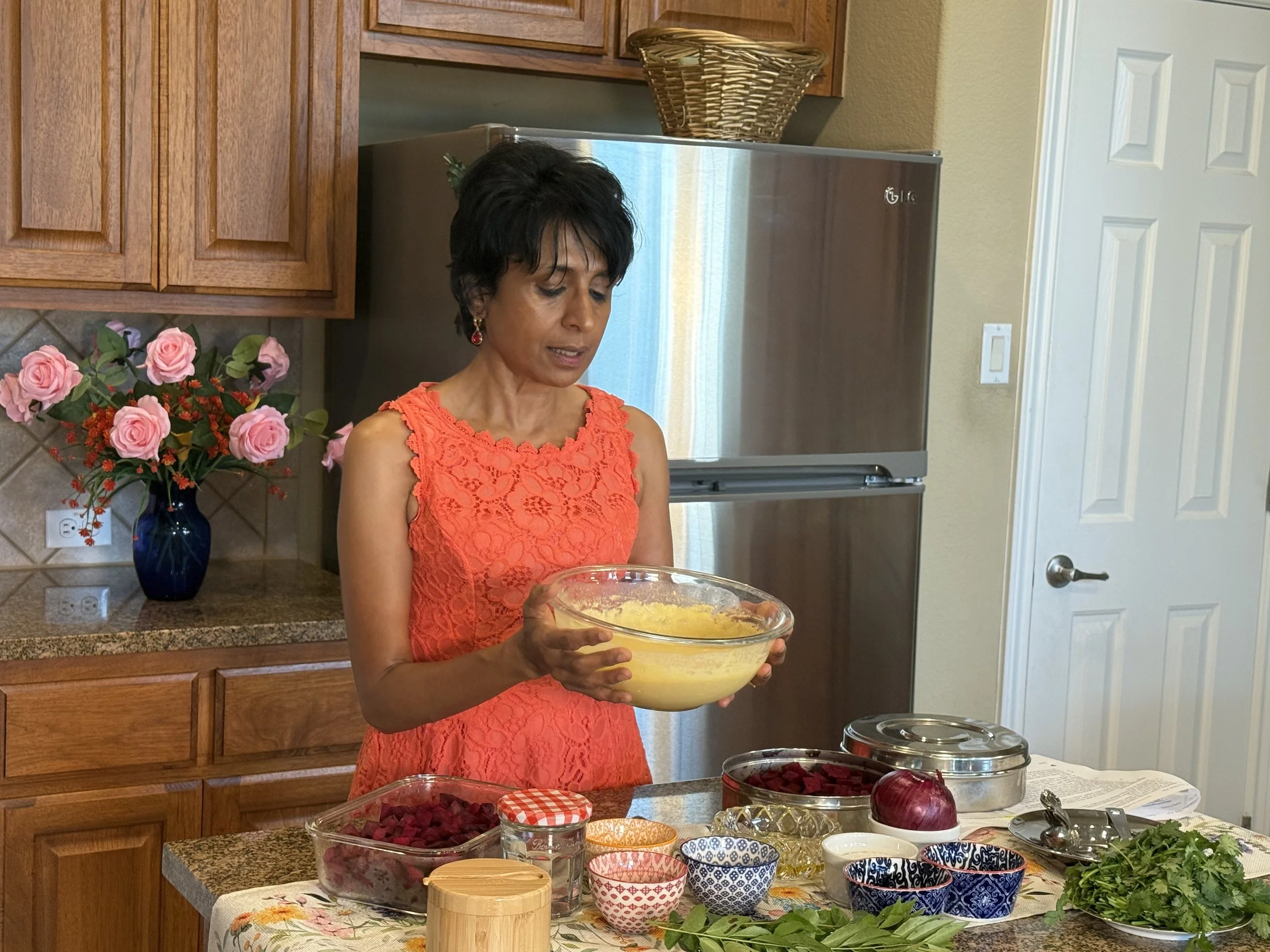 Asha Paul demonstrating healthy cooking techniques with vibrant ingredients in the Cooking Club