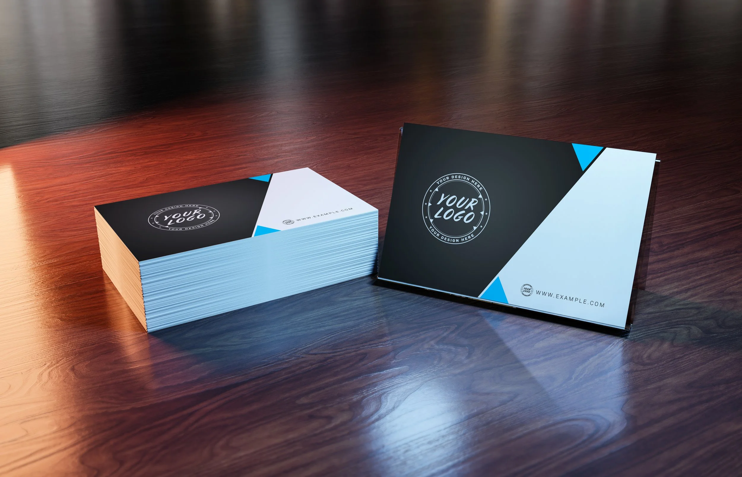 Stack of business cards and a booklet with a black, white, and blue geometric design on a wooden table.