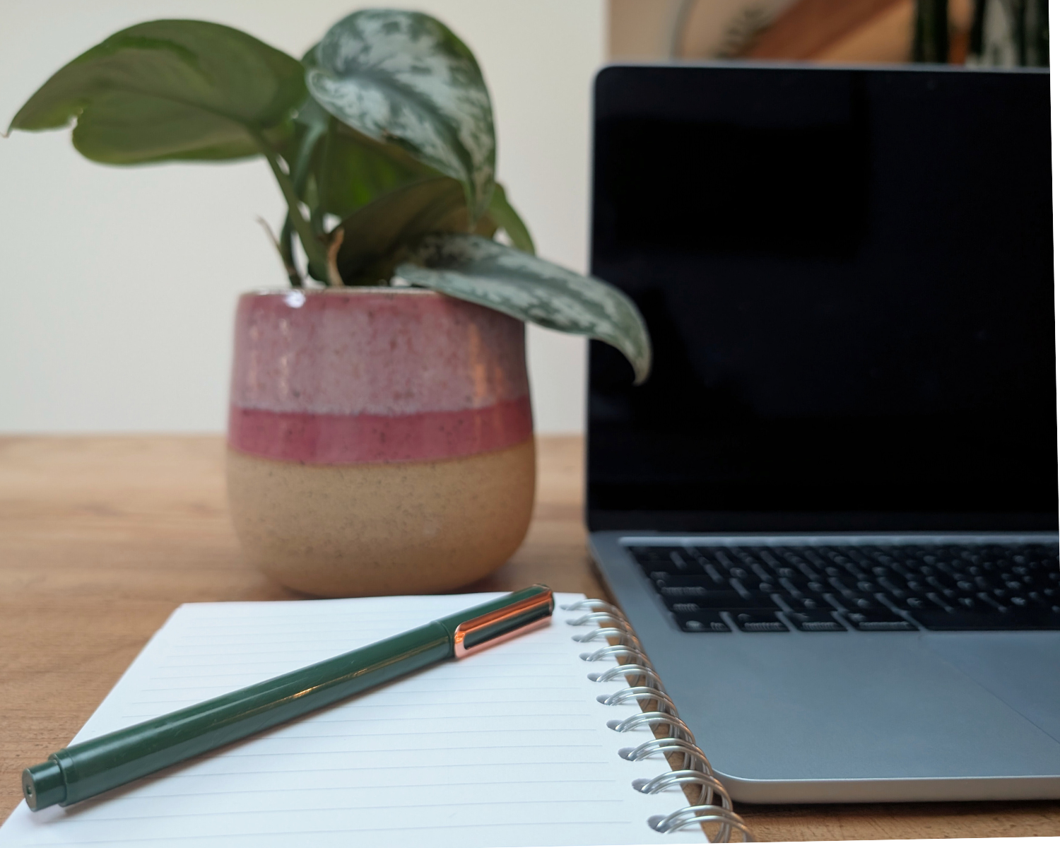 Email marketer with laptop, notebook, and pen