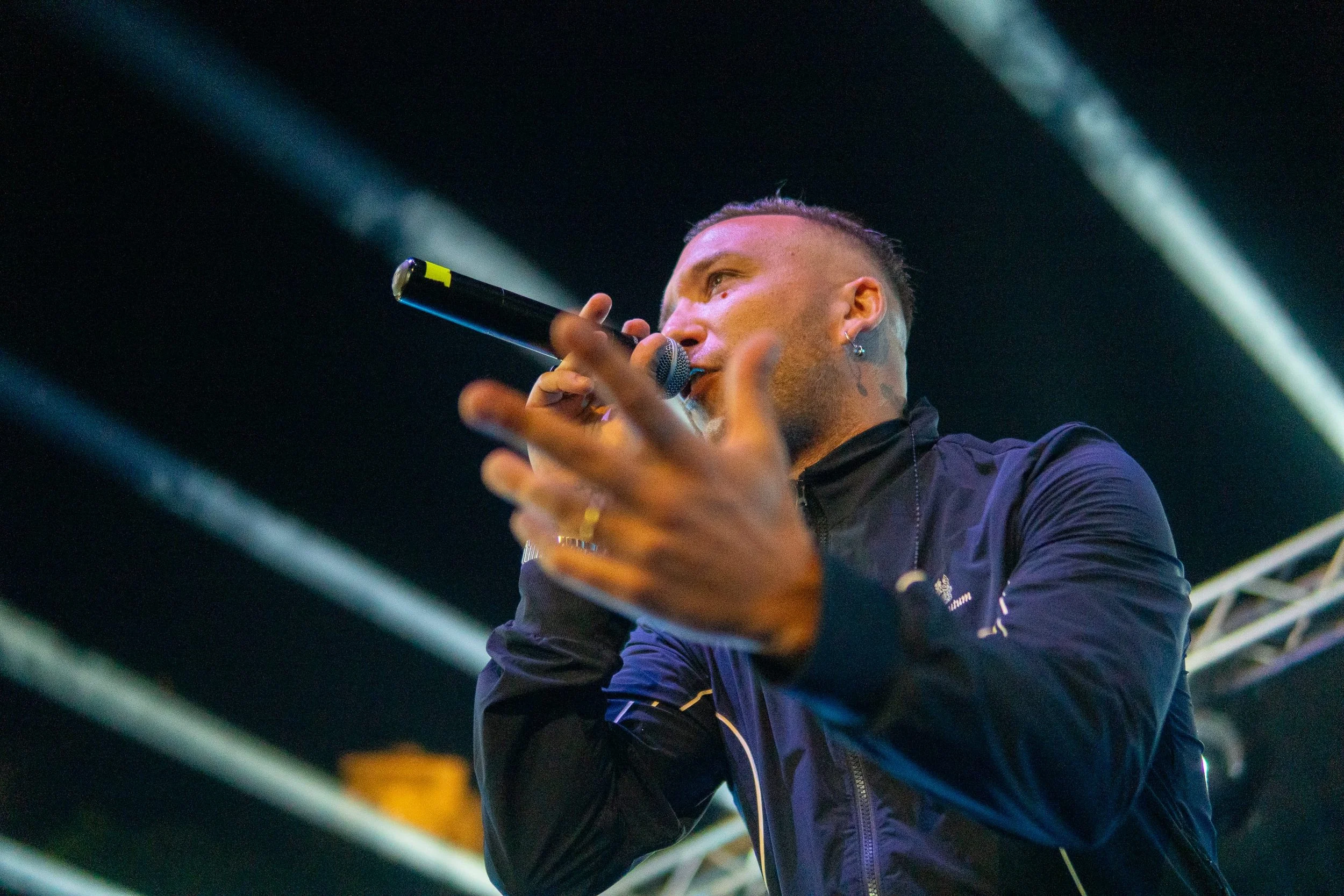 Un cantante che tiene un microfono durante un'esibizione sotto luci teatrali