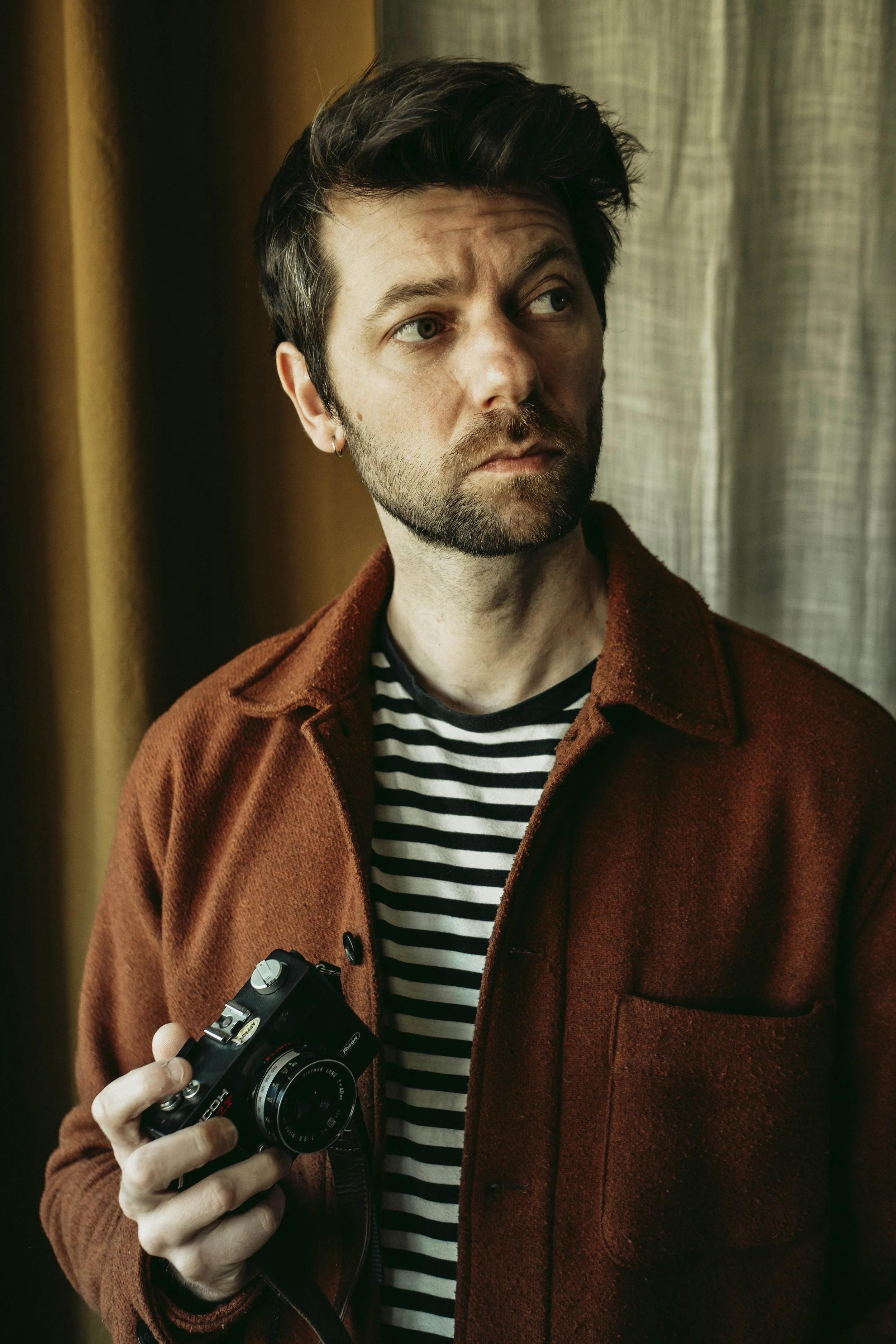 Portrait du photographe tenant un appareil photo à la main.