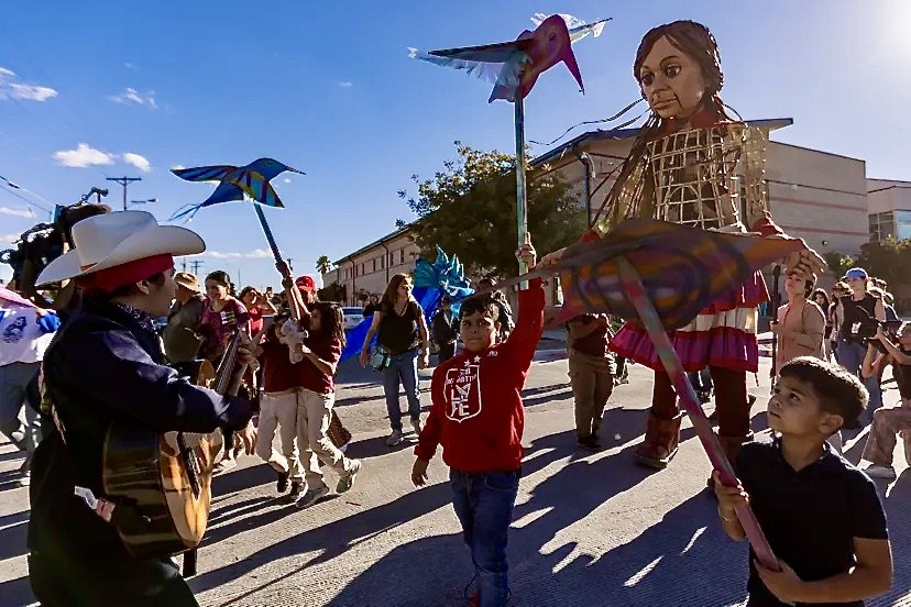 Hummingbirds made and flown by neighborhood youth greeting Little Amal in Segundo Barrio,  El Paso TX.