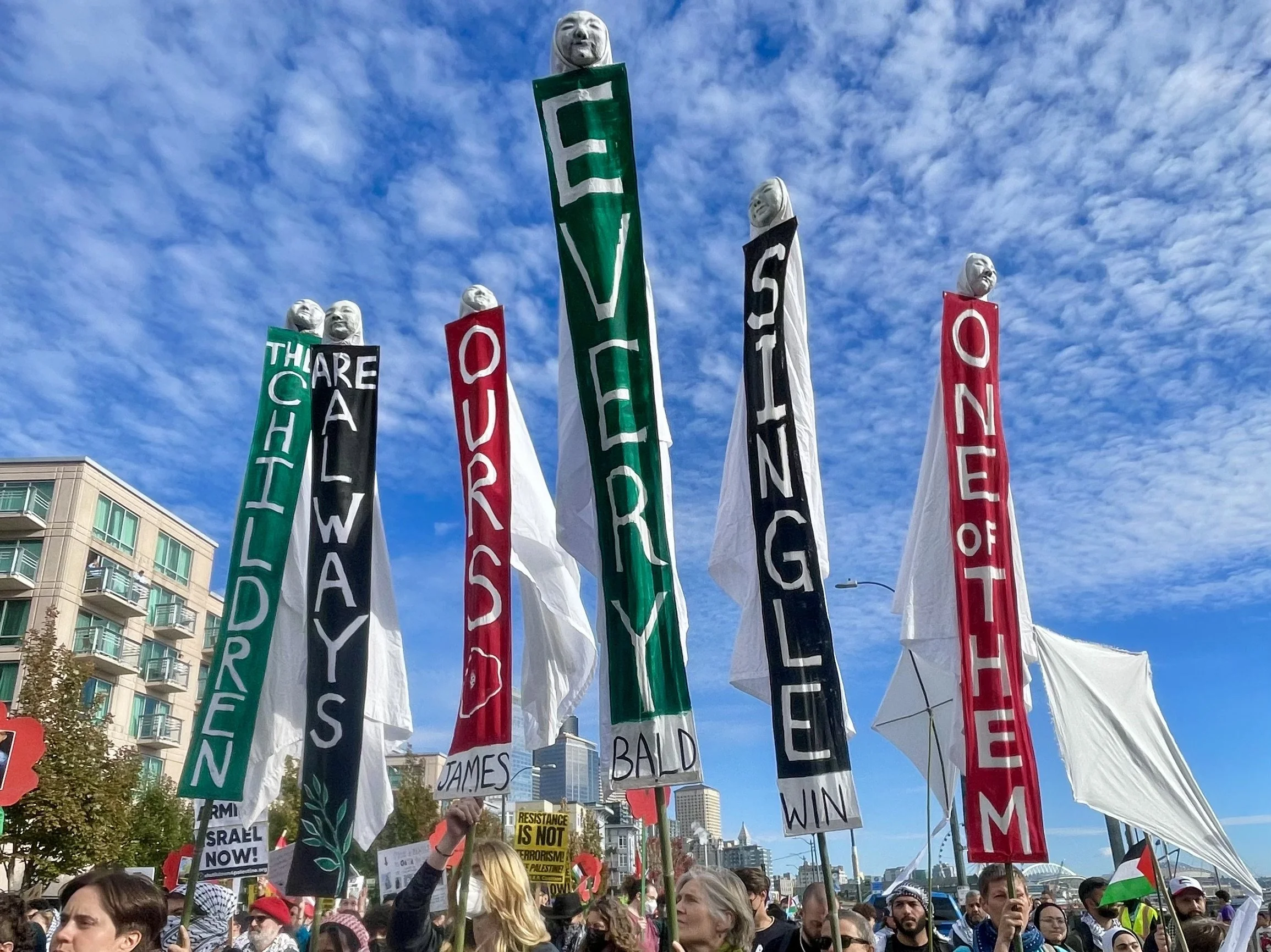 Martyred Babies Standards featuring James Baldwin quote  "The Children Are Always Ours..." at Global March for Palestine, 2024, Seattle WA.