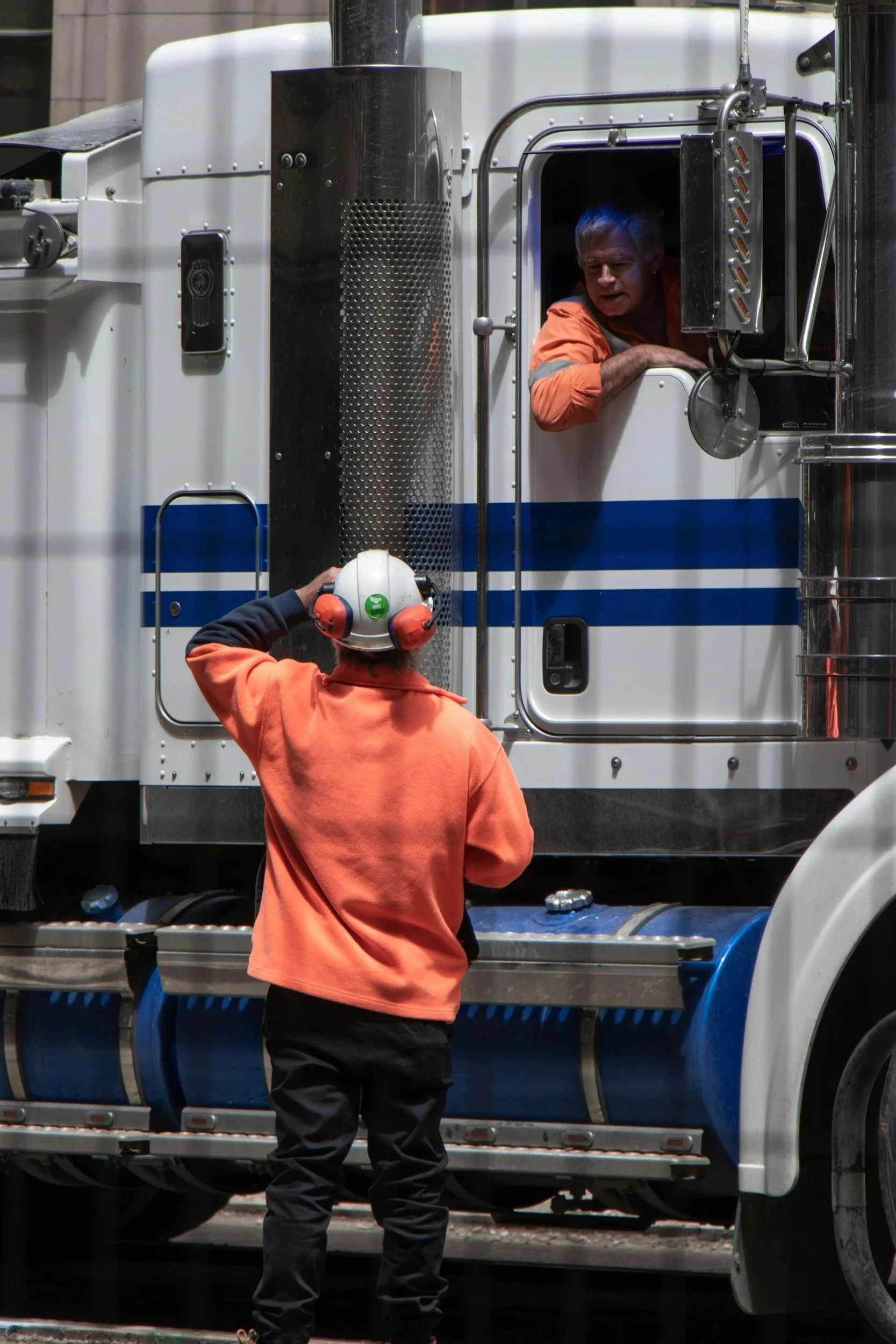 Workers talking in semi-truck on job site