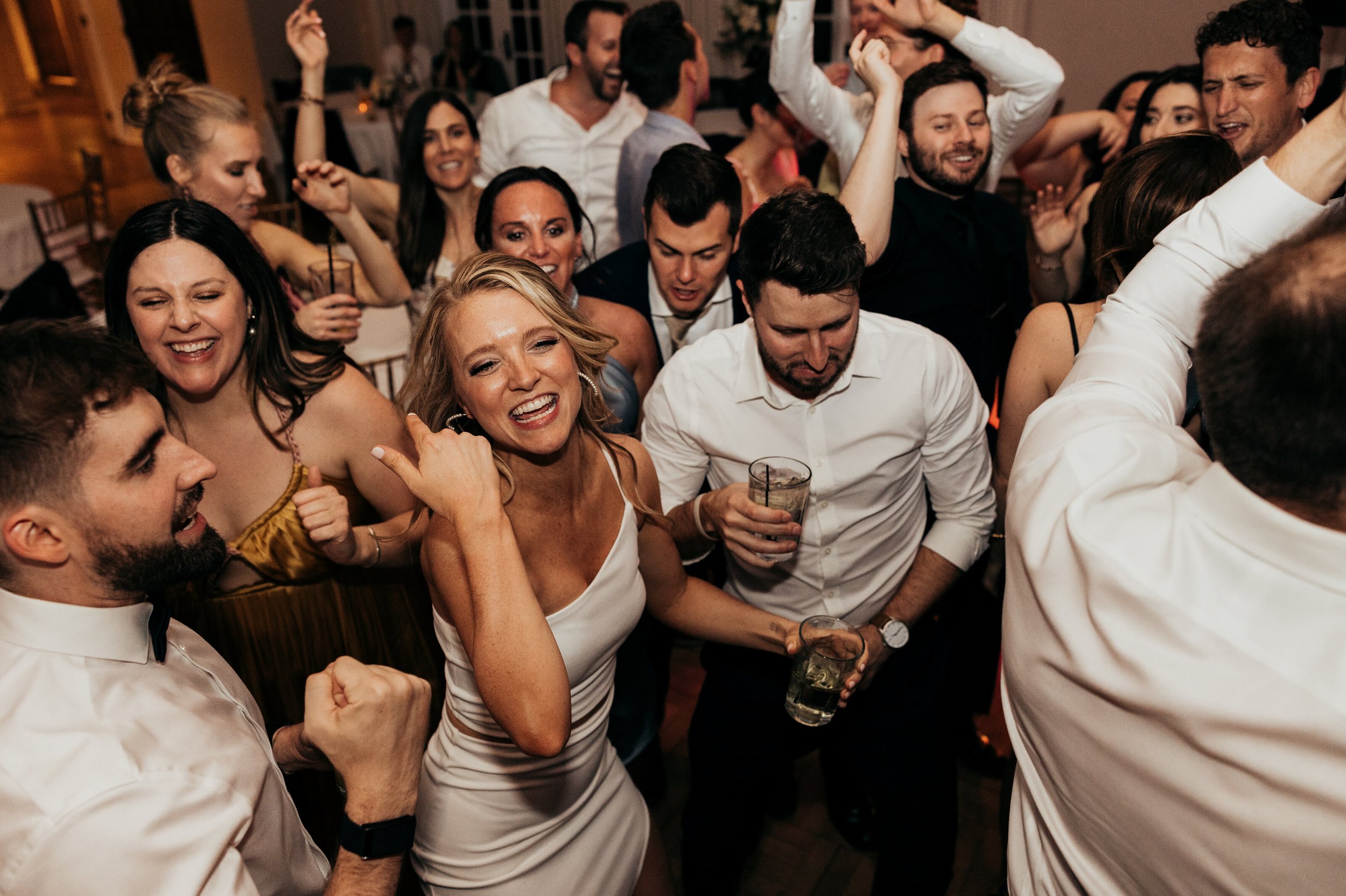 Group of people dancing and celebrating at a party, smiling and enjoying themselves.