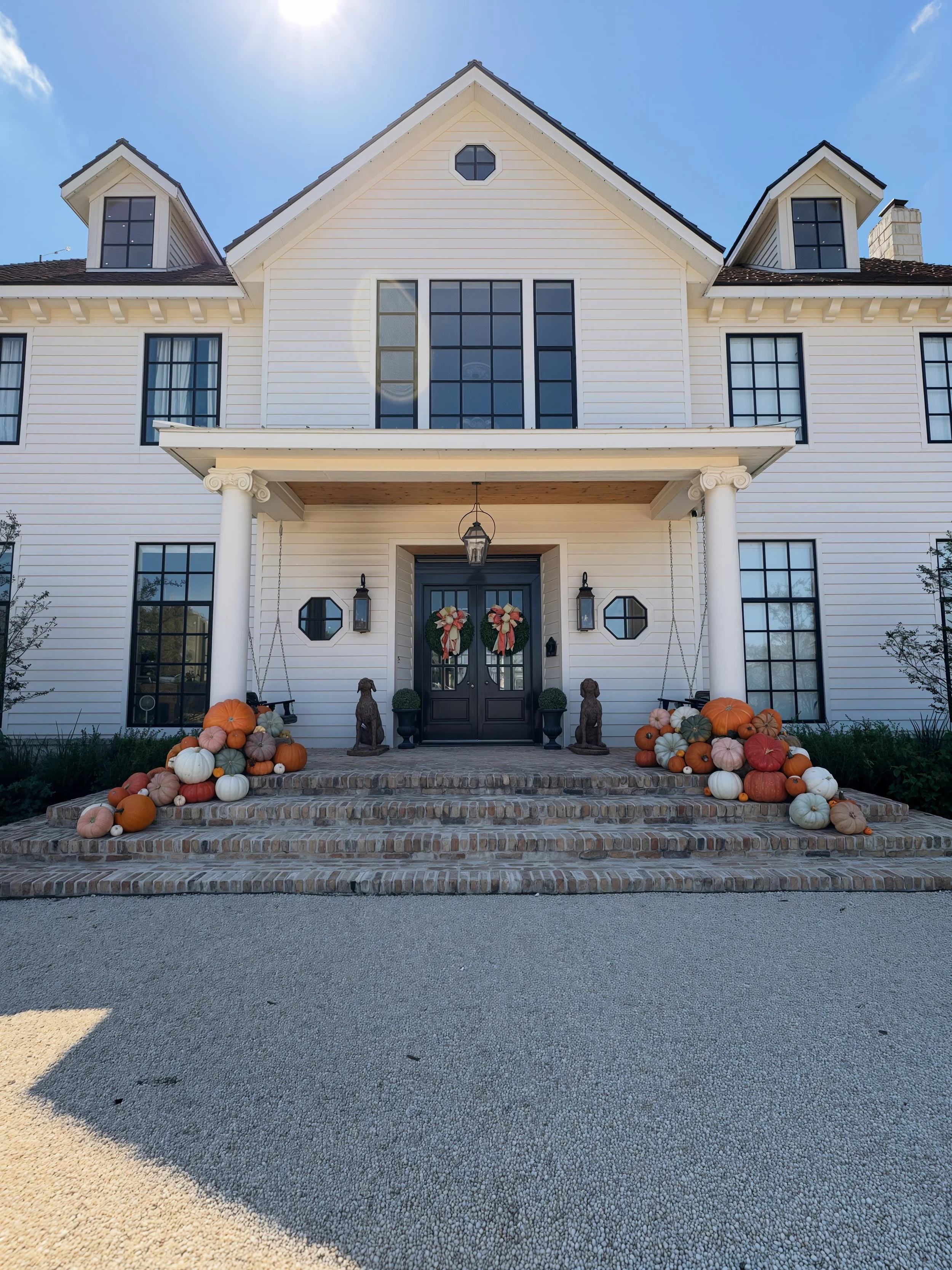 Luxury pumpkin porch display with Big Mac pumpkins, Cinderellas, and specialty varieties arranged by The Pumpkin Parlor in San Antonio