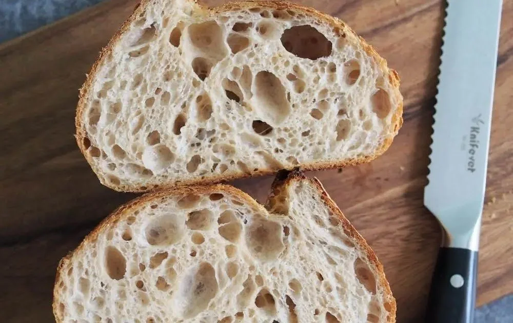 To skiver med baguett, et kniv og et trebord.