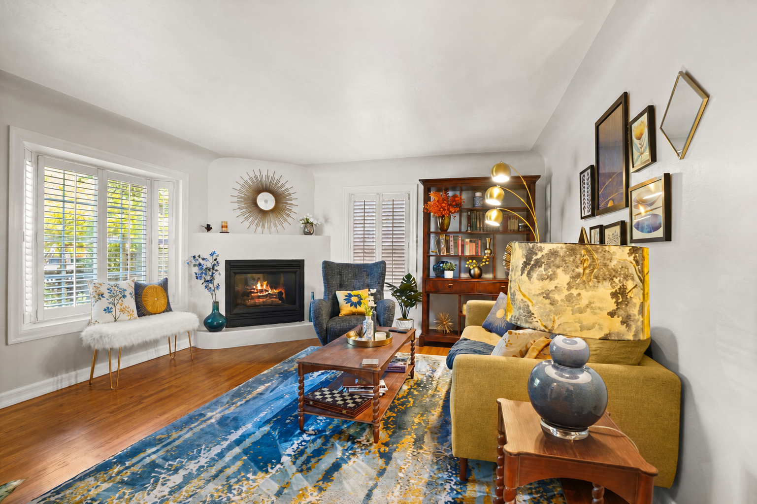 Bright living room with a fireplace, blue and yellow accents, and wall art.