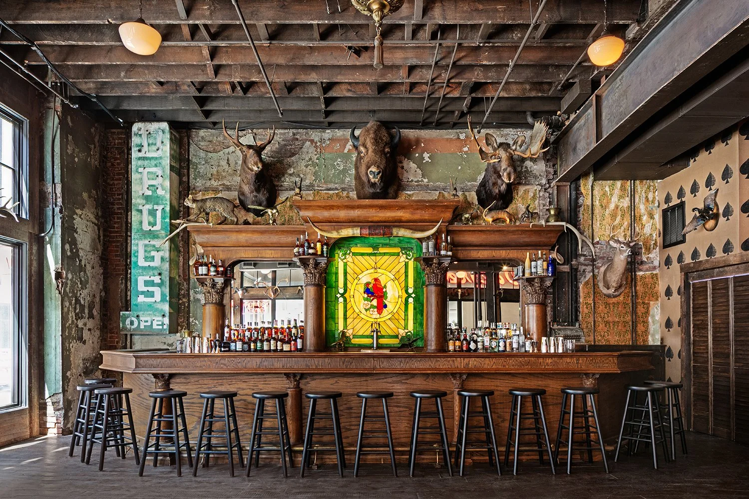 Rustic Cowboy Saloon - Belly up to the bar in a stool, stained glass center, organized and clean alcohol bottles in the bar