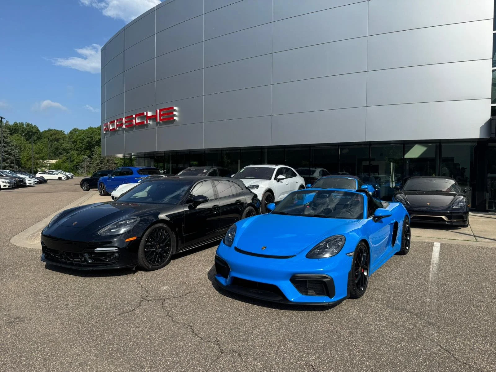 Blue Porsche Spyder outside a Porsche dealership