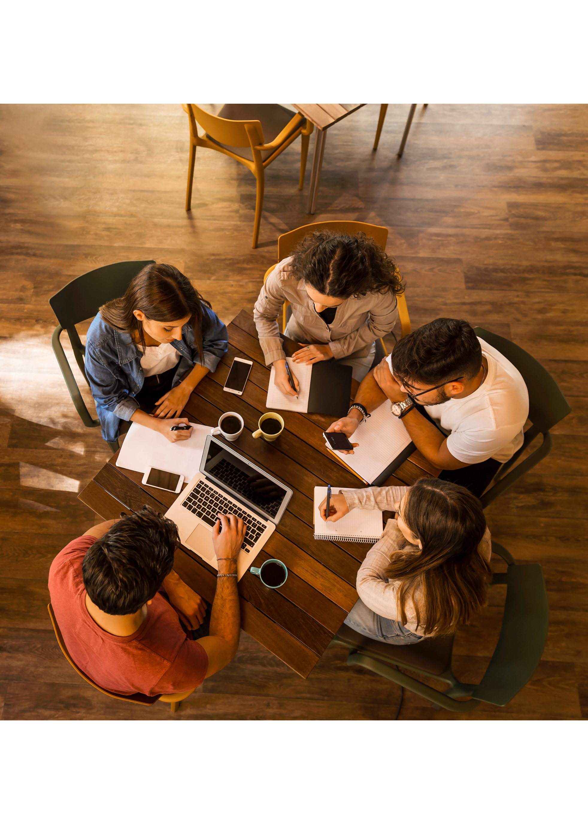 Team collaborating around a table, reflecting clarity, communication, and leadership through Ruth Olson’s coaching approach.