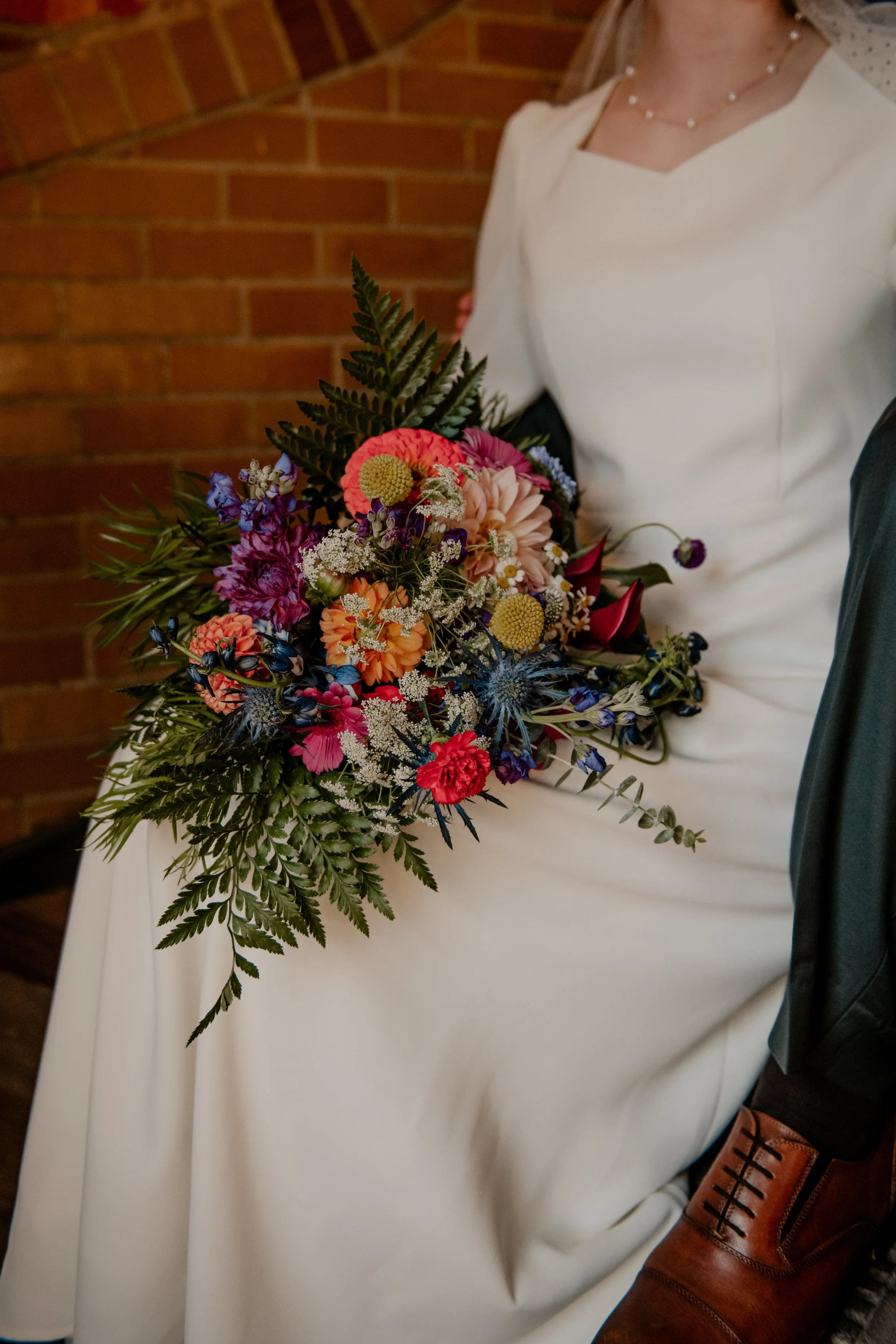 A bride's colorful bouquet sitting on her lap