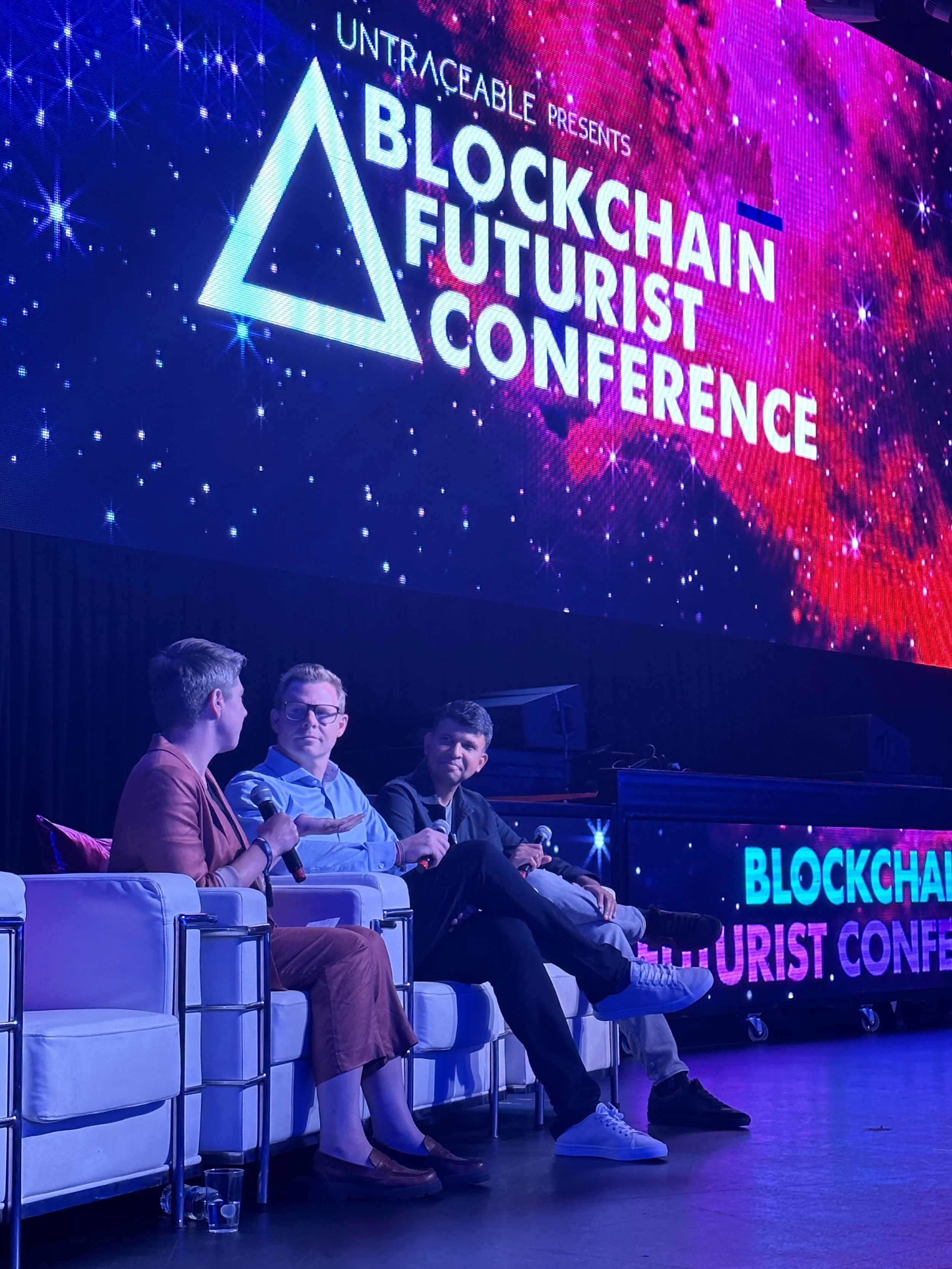 Three featured speakers on stage at the Blockchain Futurist Conference