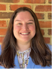 A woman smiling in front of a brick wall