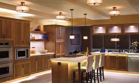 Modern kitchen with wooden cabinets, an island with seating, a microwave, and pendant lighting.