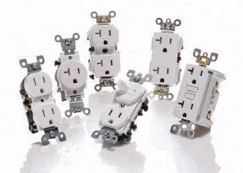 Different types of electrical outlets and switches arranged on a white surface.