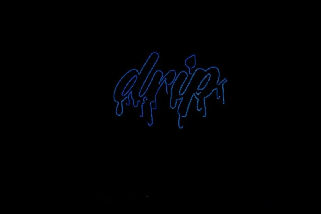 Neon sign with the word "drink" in blue cursive writing on a black background.