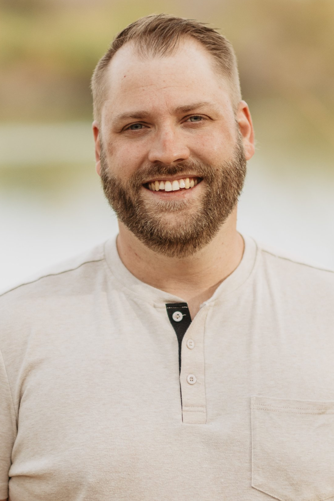Smiling man with light brown hair, beard, and wearing a light-colored shirt standing outdoors with a blurred background. Michael Swearingen is the lead pastor of Coastline Christian Church in Sarasota, Florida