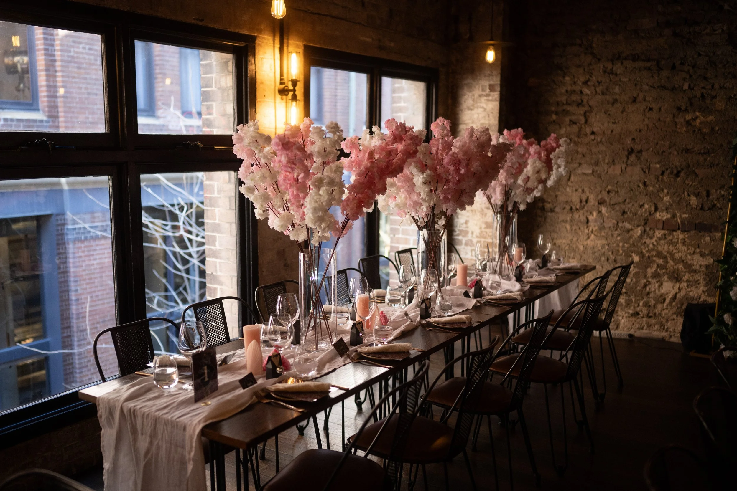 Moody and industrial wedding venue with cherry blossom flower arrangements.