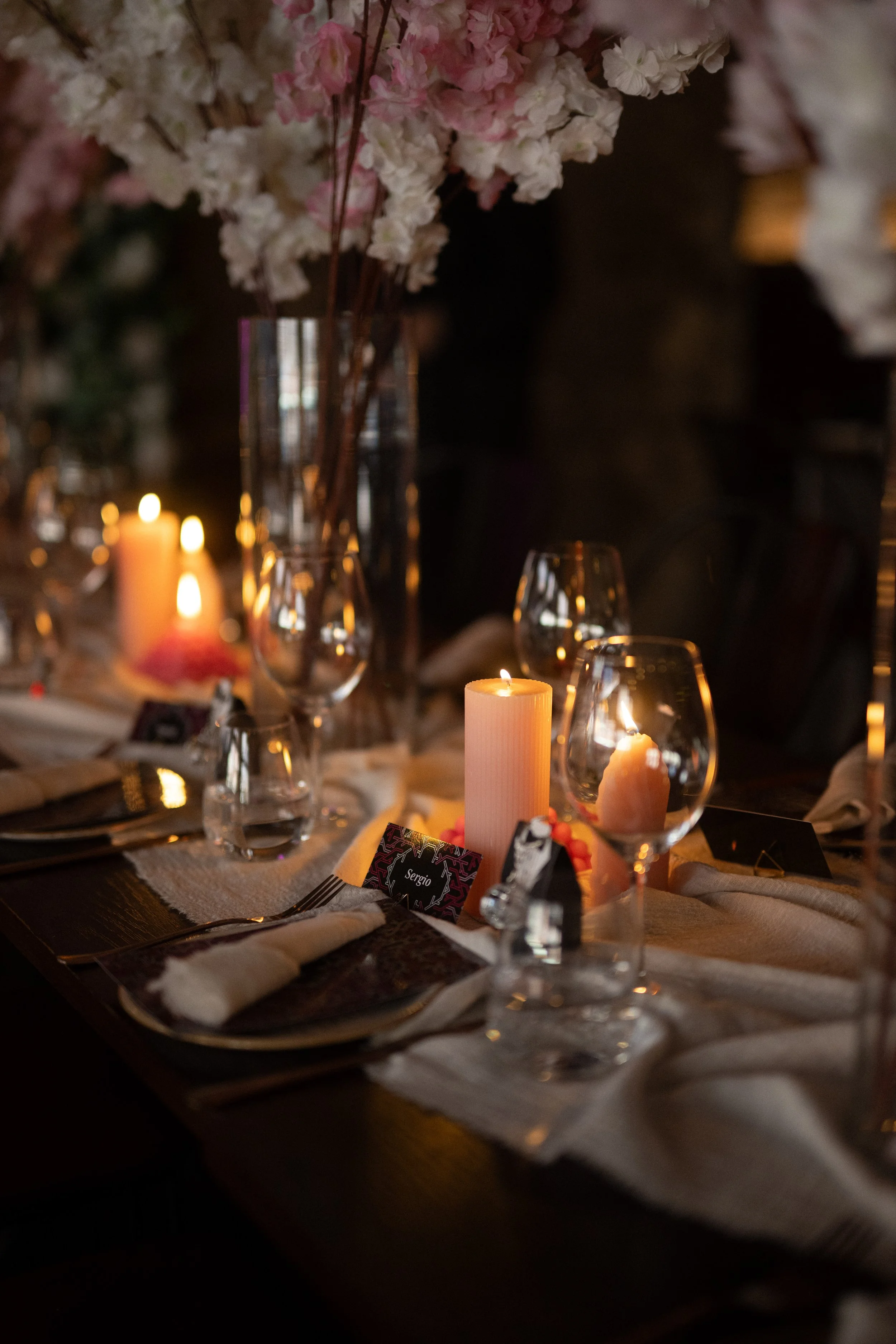 Detail of wedding table setting with cherry blossoms and candles.