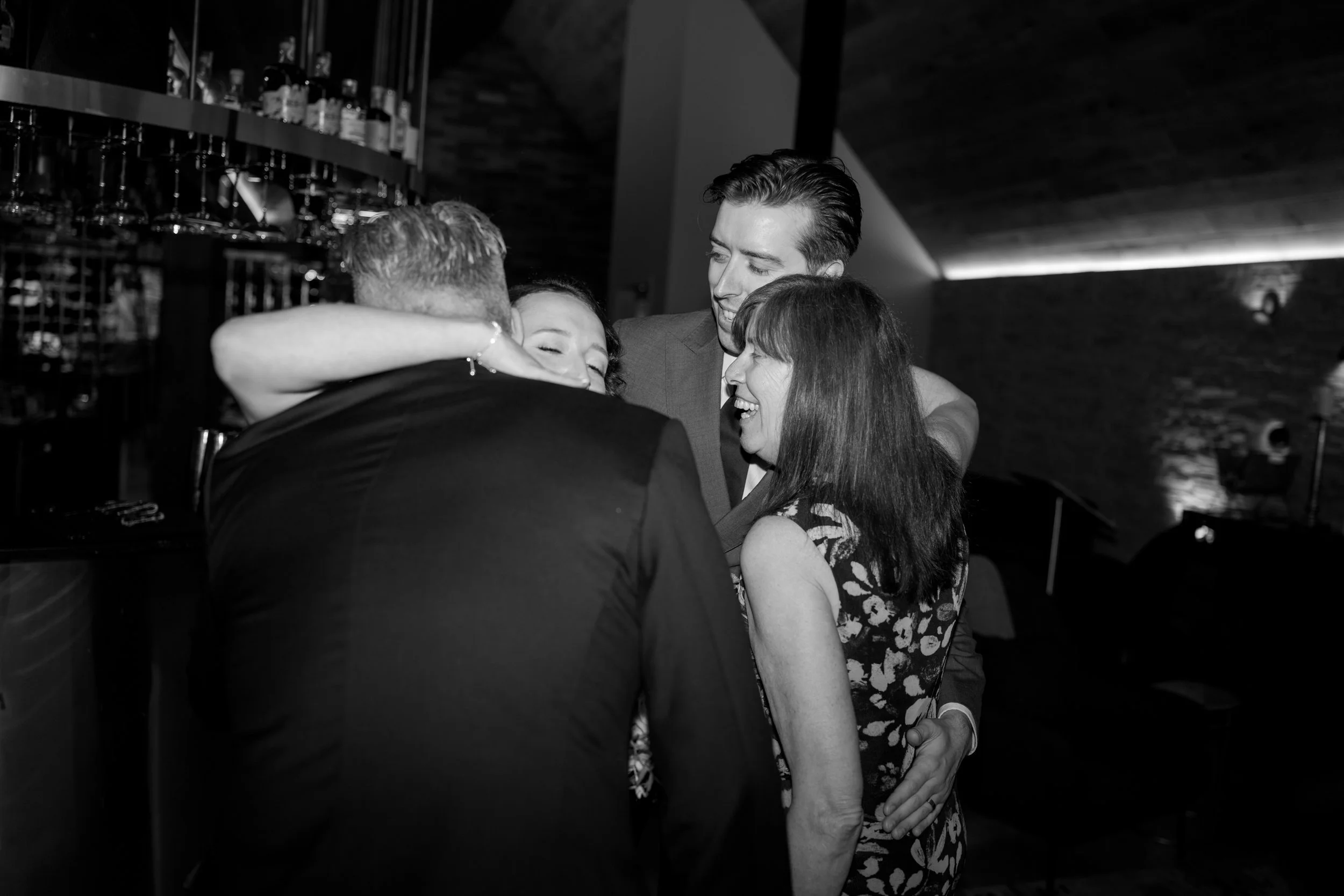 Film + Digital Wedding Photographer Queenstown - Kāmana Lakehouse, Queenstown, Otago, New Zealand. Guests hugging the bride and groom during wedding reception.