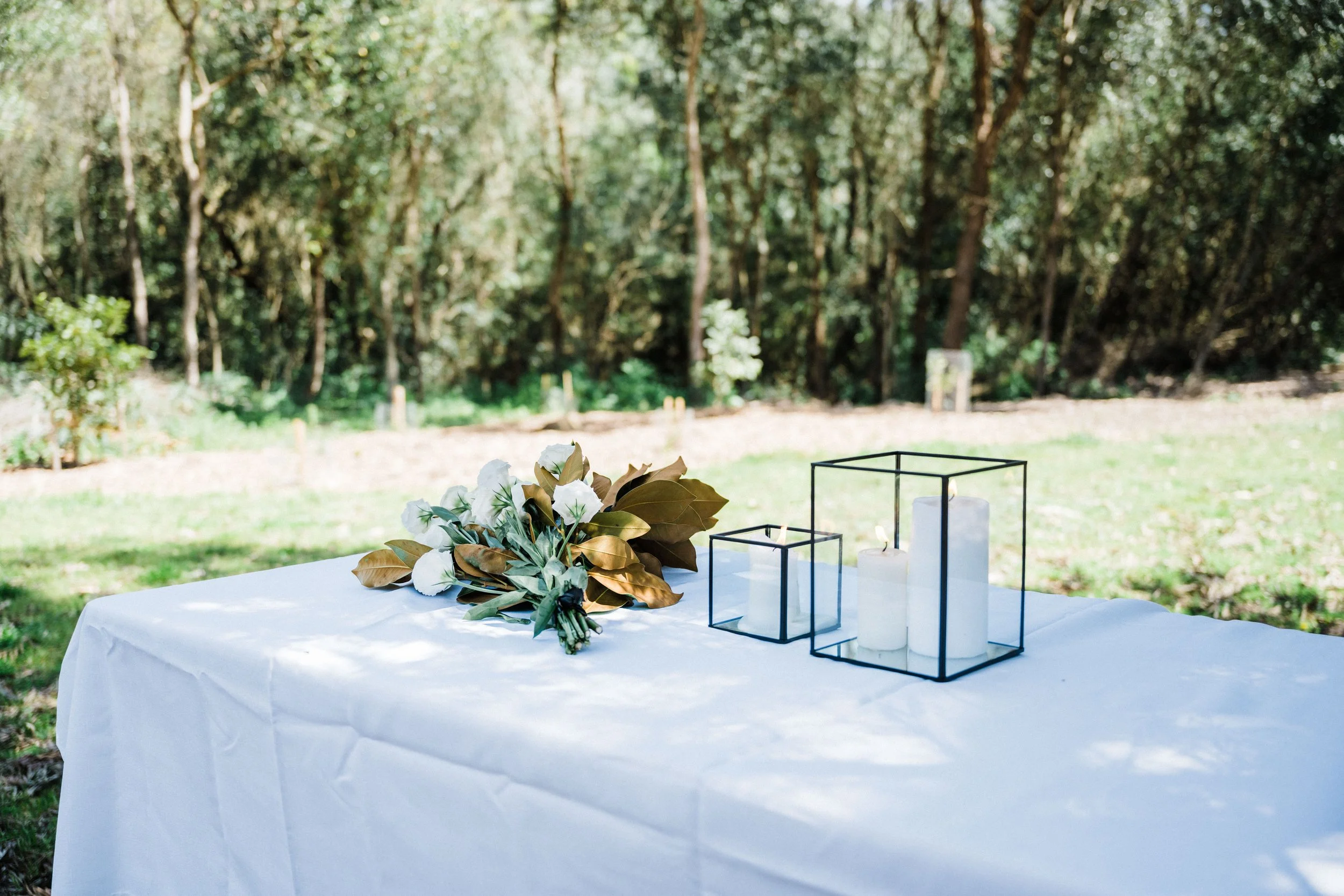 Wedding bouquet and candles. Outdoor wedding venue.