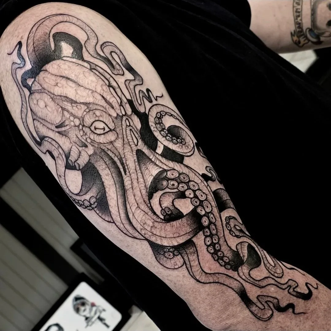 Line art tattoo of an octopus with detailed tentacles on person's arm.