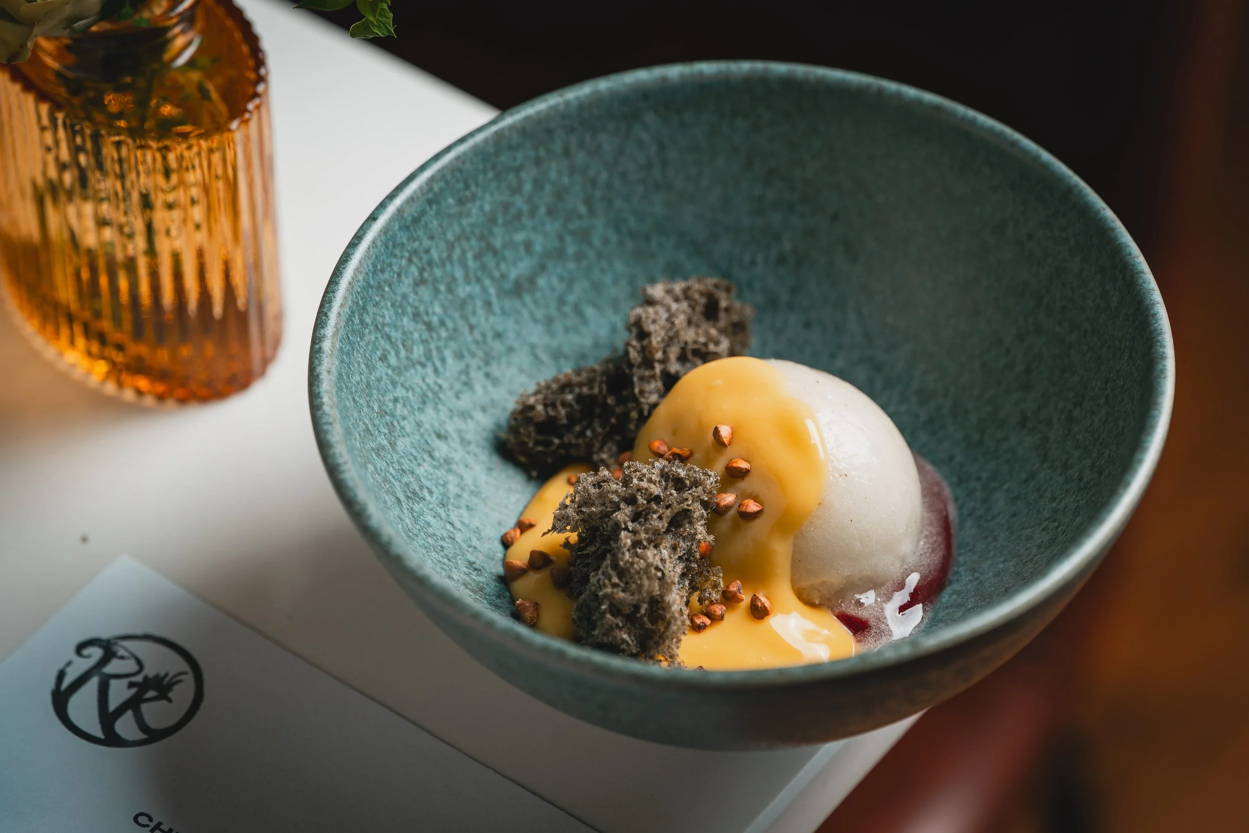 Dessert plate with sponge cake, meringue, a dollop of cream with a cherry topping, and a scoop of vanilla ice cream