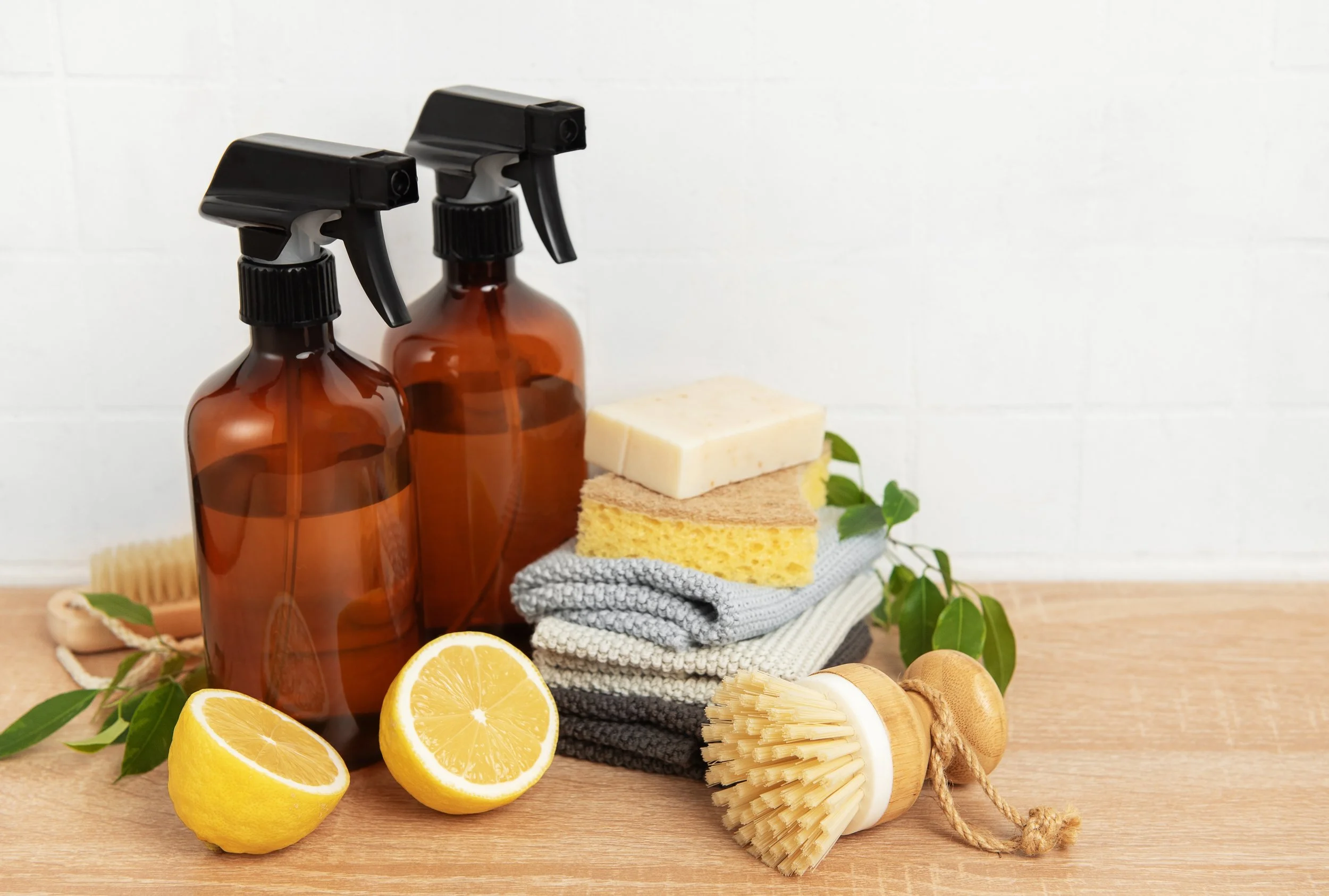 A blue dustpan with a wooden-handled brush resting inside it, hanging on a wall.