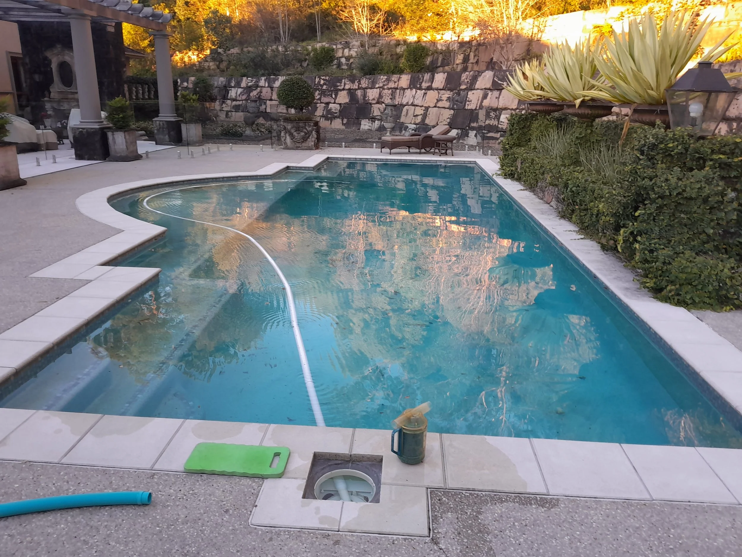 curved-swimming-pool-stone-garden-wall-clarity-pool-services.jpg