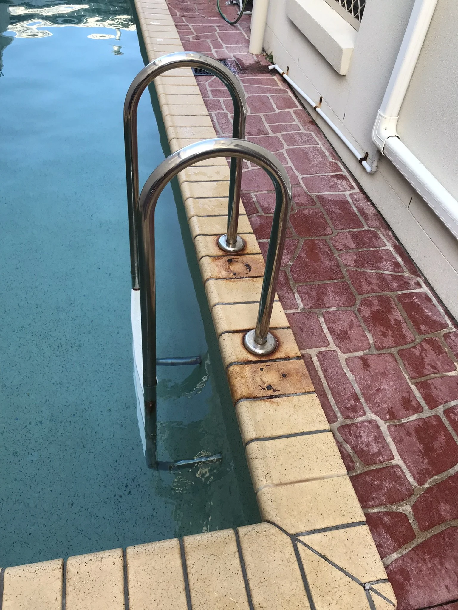 Deteriorated pool ladder beside a narrow lap pool at a Parrearra rental property